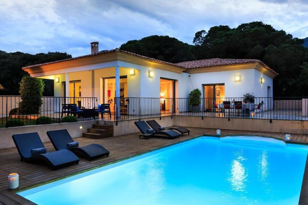 una piscina con sedie e una casa di Villa La Pinède - Calvi a Calvi