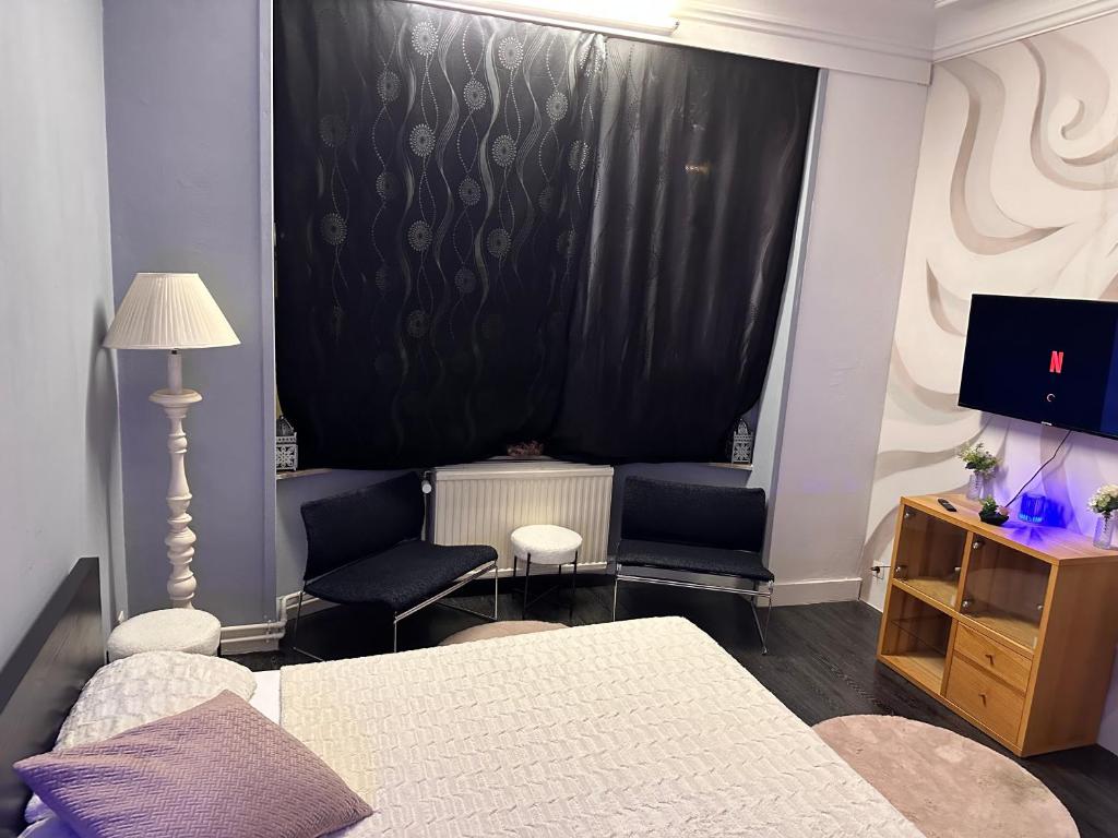 a bedroom with a bed and a window with a black curtain at Chambre Neptune in Brussels