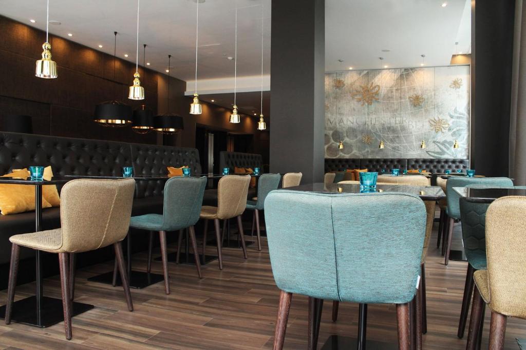a dining room with blue chairs and tables at Motel One Manchester-Piccadilly in Manchester
