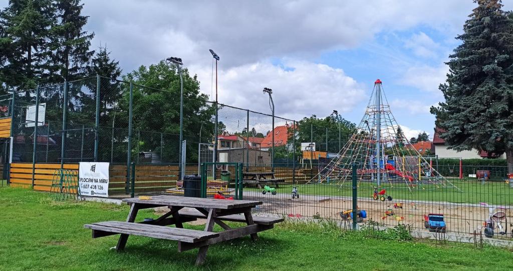 a park with a picnic table and a playground at Guest House KRISTI in Tuchoměřice
