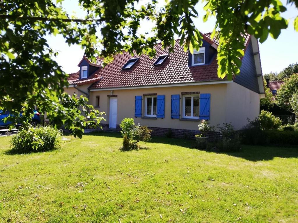 une maison blanche avec des fenêtres bleues et une cour dans l'établissement Maison Côte Et Champs, à Doudelainville