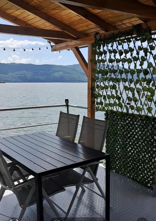 a table and chairs on the deck of a boat at Apartament Laura in Orşova