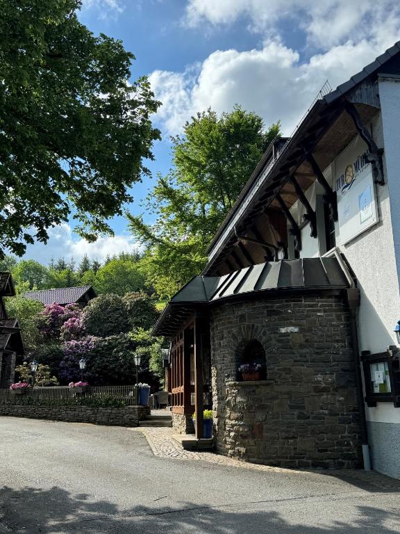 un edificio de ladrillo con toldo en el costado en Hotel Zur Mühle, en Iserlohn
