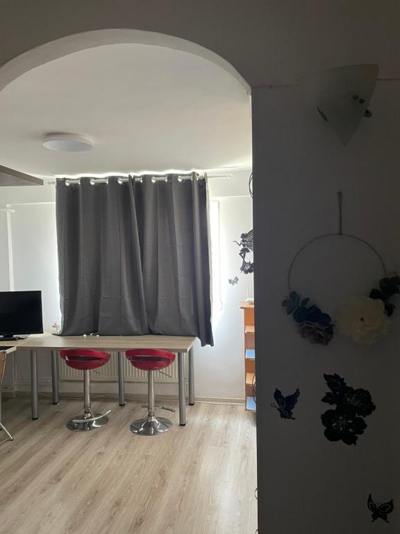 ブカレストにあるStudio Ianisのカーテンの前にテーブルと2脚の椅子がある部屋