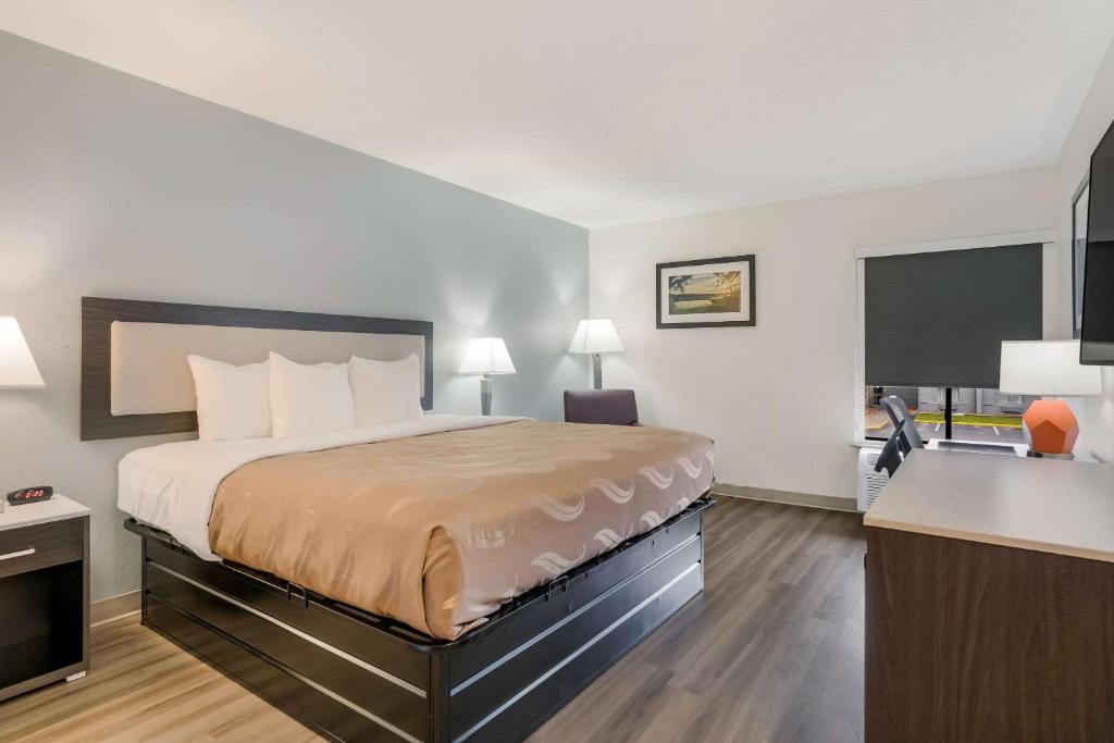 a hotel room with a bed and a kitchen at Quality Inn Jacksonville near Camp Lejeune in Jacksonville