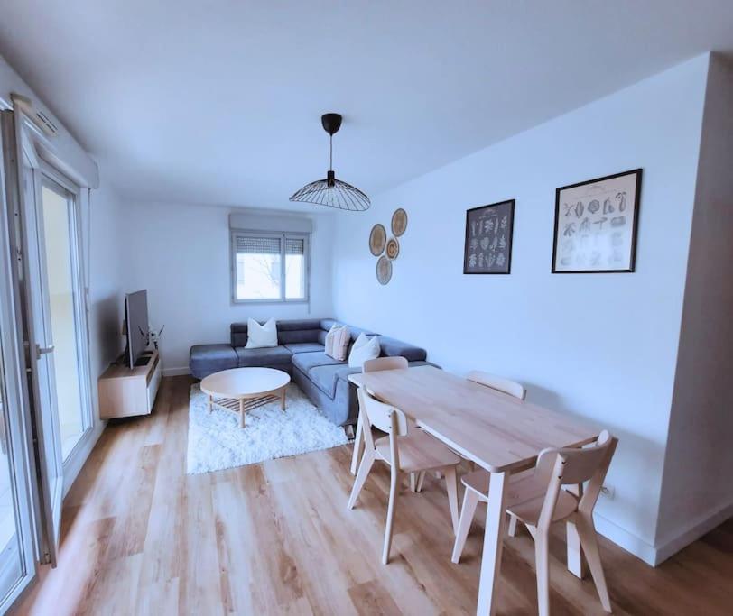 un salon avec un canapé bleu et une table dans l'établissement Souriez c'est convivial, à Toulouse