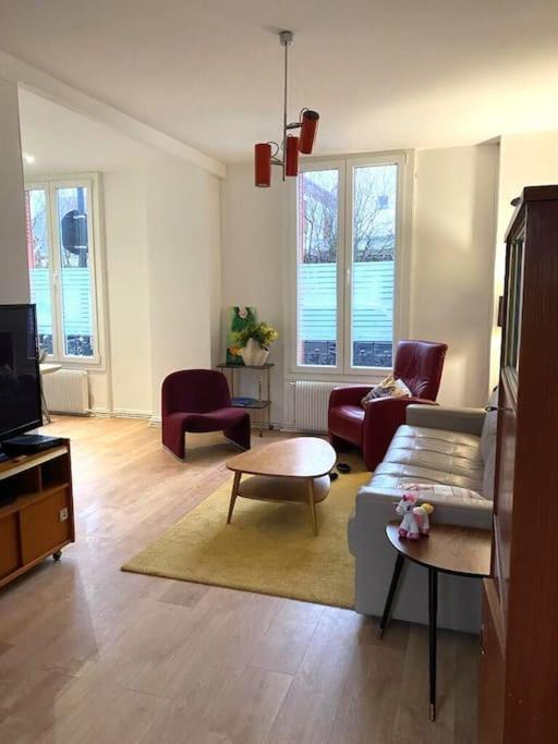 un salon avec un canapé, des chaises et une télévision dans l'établissement Le Brétigny Logement 6 personnes, à Joinville-le-Pont