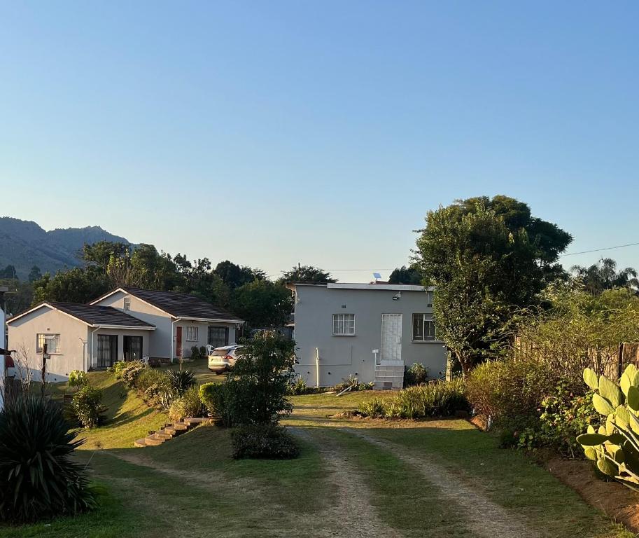 a yard with houses and a dirt road at African Violet in Mbabane