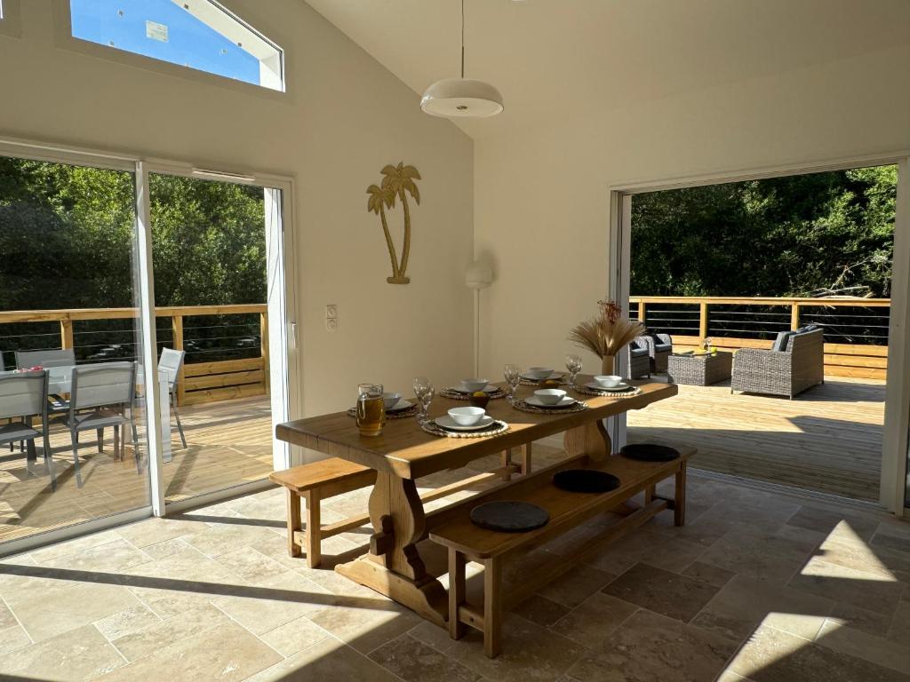 un salon avec une table en bois et une terrasse dans l'établissement Charmant ensemble de 2 villas, à Léon