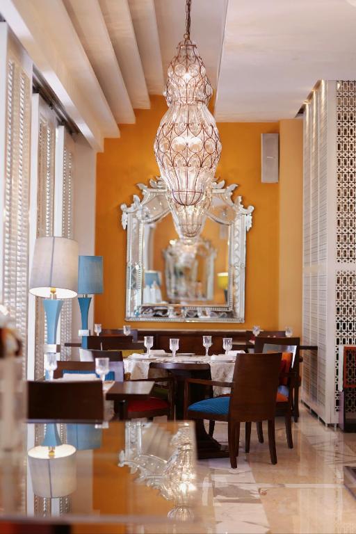 a dining room with a large mirror and a chandelier at The Leela Ambience Gurugram Hotel & Residences - The Luxury Urban Sanctuary in Gurgaon