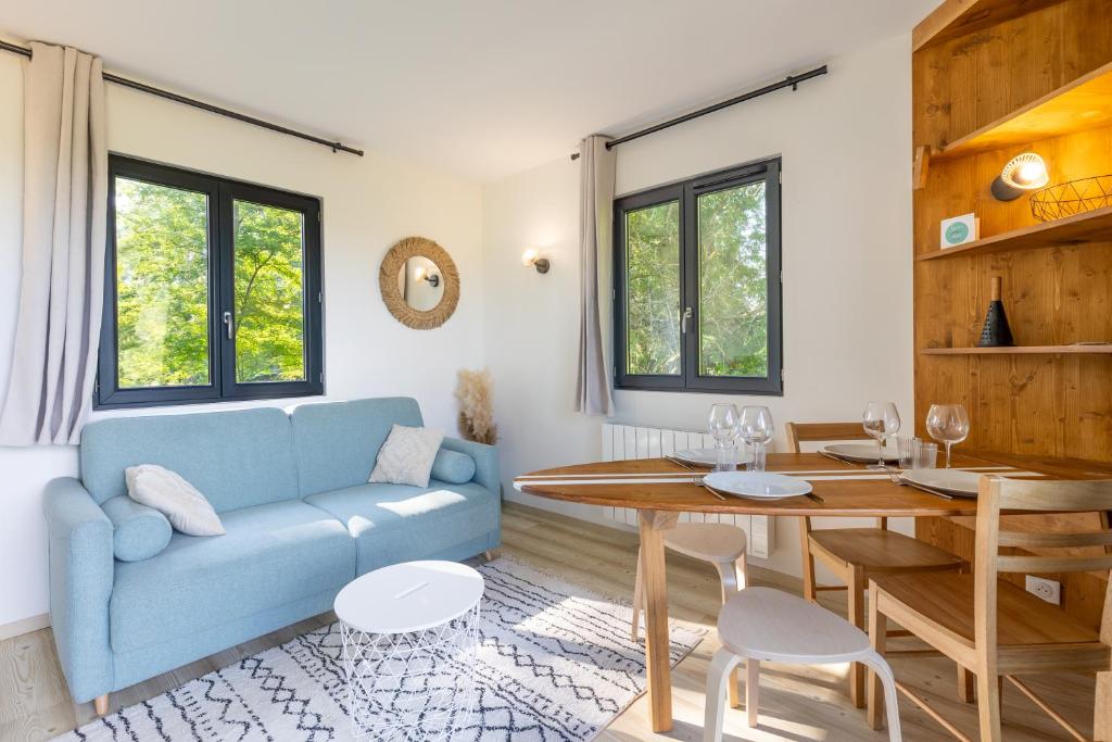 a living room with a blue couch and a table at La Cabane Ô Rêves in Genouilleux