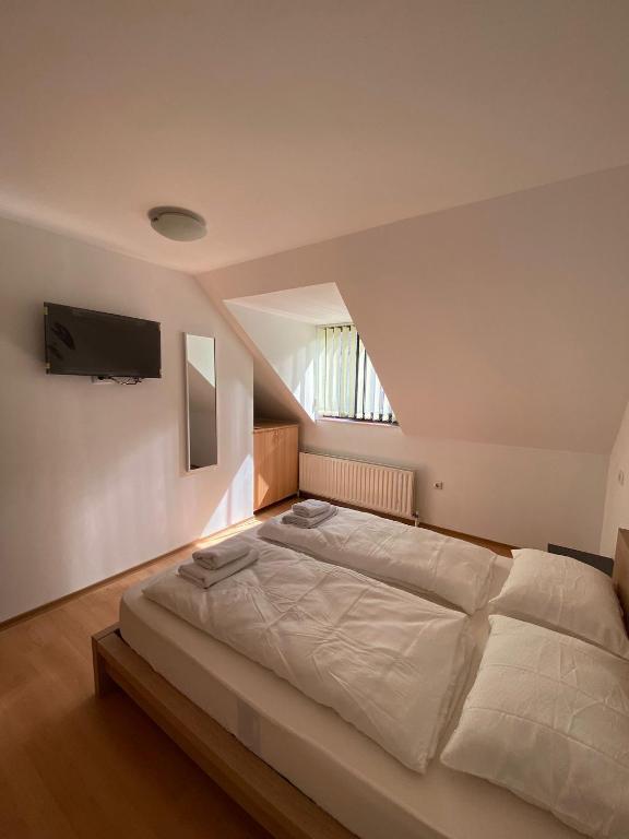 a bedroom with a large bed with a tv on the wall at MAT & EDW RooM in Câmpulung Moldovenesc