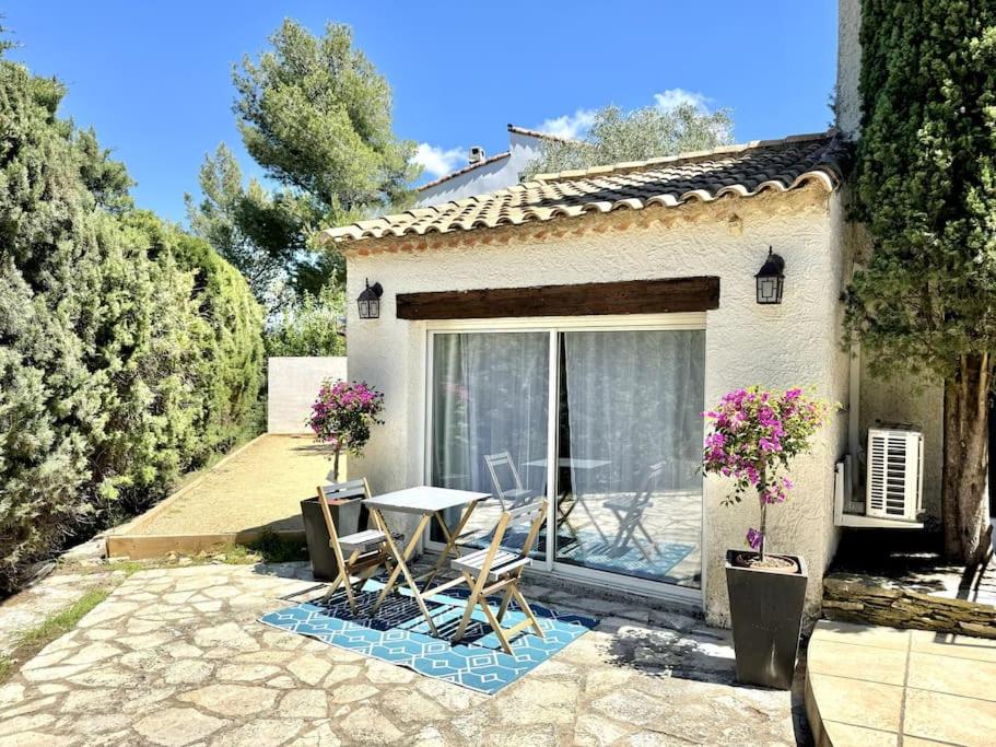 un patio avec une table et des chaises devant une maison dans l'établissement Studio proche Cassis climatisé, à Carnoux-en-Provence