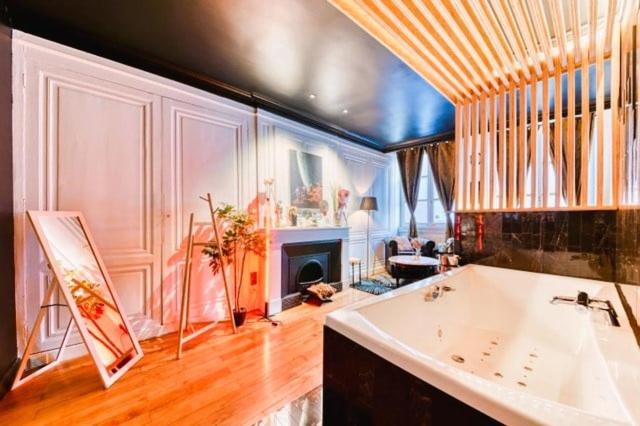 une grande chambre avec une baignoire et un salon dans l'établissement GuestReady - L'intime -Balneo Hyper Centre, à Lyon
