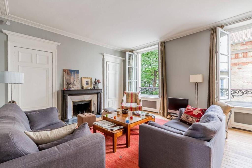 un salon avec deux canapés et une table dans l'établissement GuestReady - Bel Apt pour 4 / Luxembourg -Assas, à Paris