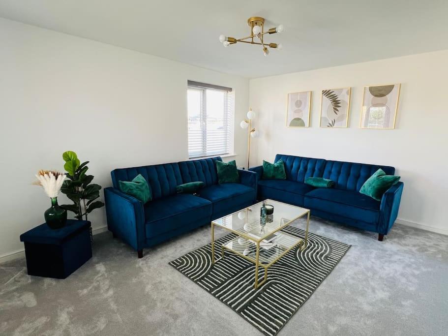 a living room with a blue couch and a table at Beautiful 3 Bed Detached House in Grimsby in Little Coates