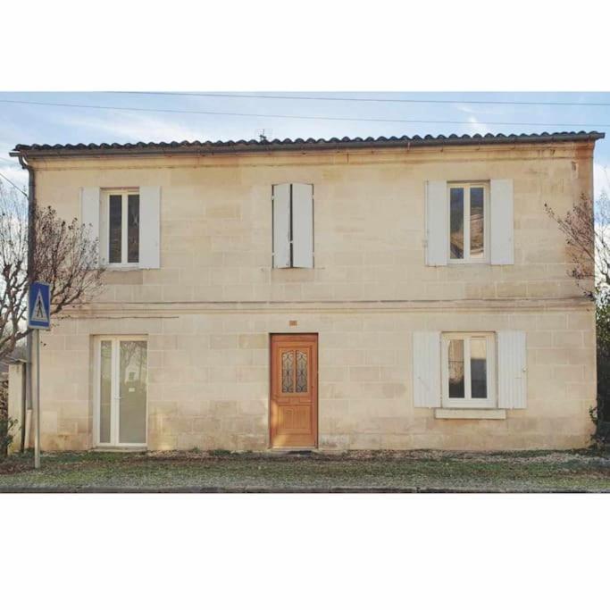 une grande maison en briques avec une porte marron dans l'établissement Charmante maison Girondine, à La Rivière