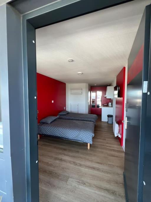 une chambre avec deux lits et un mur rouge dans l'établissement JOIA Bassin d'Arcachon- NOTRO 209, à La Teste-de-Buch