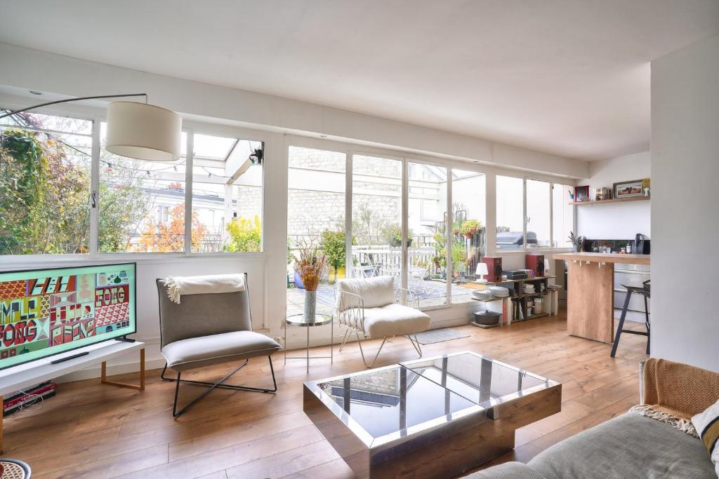un salon avec un canapé et une télévision dans l'établissement GuestReady - Apt confortable avec terrasse au 18e, à Paris