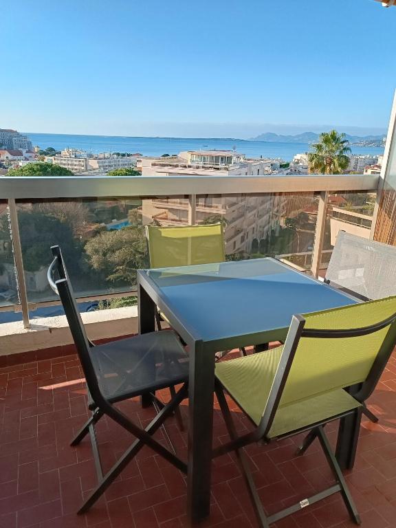une table de ping-pong et deux chaises sur un balcon dans l'établissement OLYMPE magnifique vue mer, à Antibes