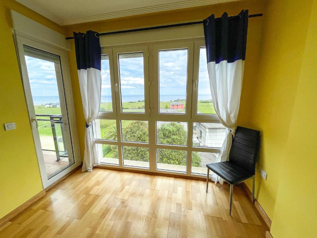 an empty room with a large window and a chair at Alojamientos Foz 3000 in Foz