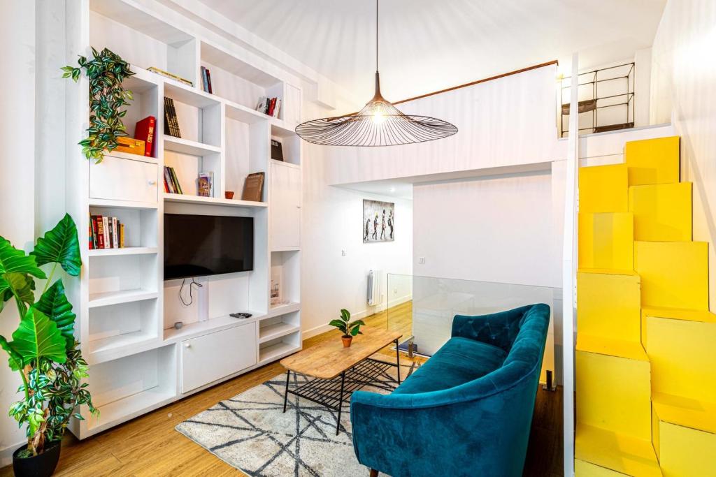 un salon avec une chaise bleue et une télévision dans l'établissement Disponible - Paris - All Equipped Souplex - From 1 to 6 Guests - Entry from 3pm - Departure up to 11am, à Paris