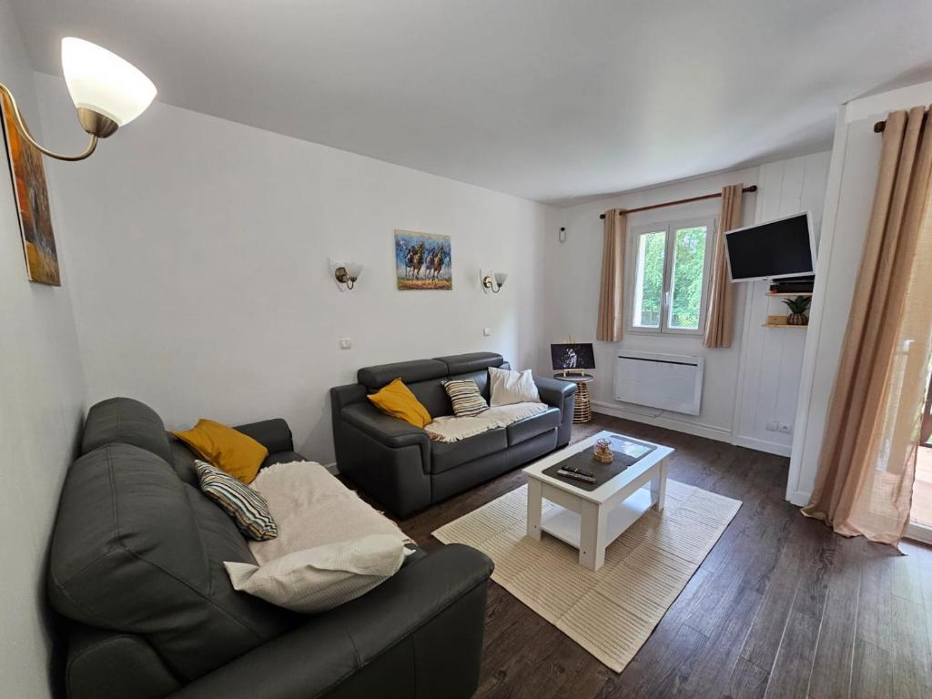 un salon avec un canapé et une table dans l'établissement Résidence du Golf, Deauville, à Deauville