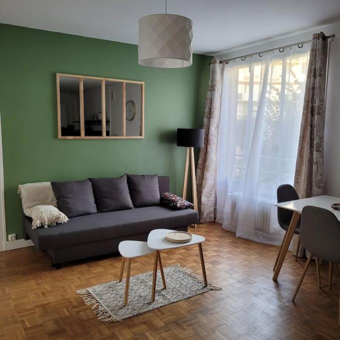 un salon avec un canapé et une table dans l'établissement Appartement en résidence - centre ville de Limoges, à Limoges