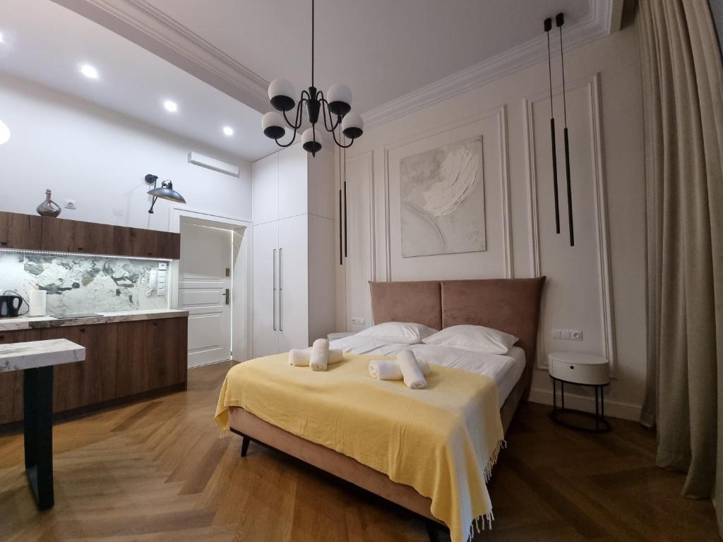 a bedroom with a bed with a yellow blanket at Apartamenty Inspiracja in Kraków