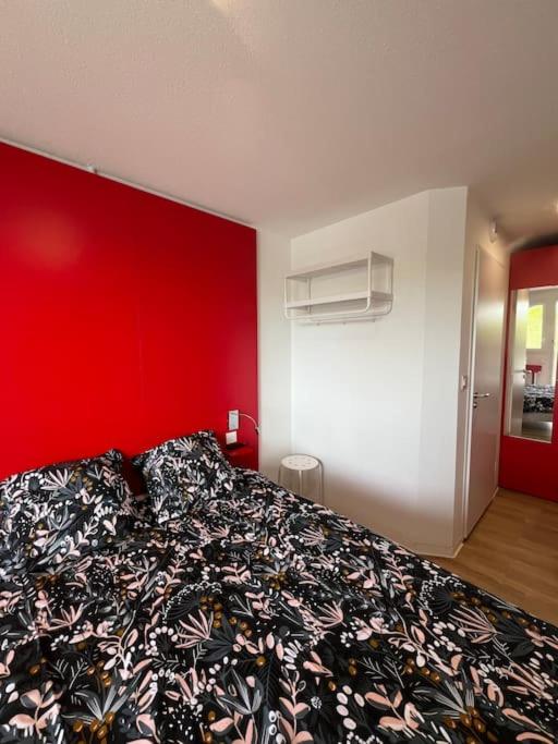 une chambre avec un grand lit avec un mur rouge dans l'établissement JOIA Bassin d'Arcachon - NOTRO 221, à La Teste-de-Buch