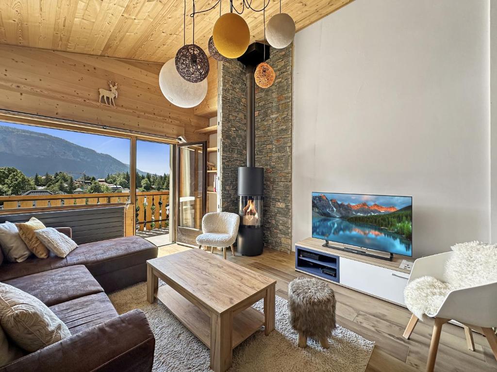 un salon avec un canapé et une télévision dans l'établissement GR450 6 Pers Centre Carroz, aux Carroz d'Arâches