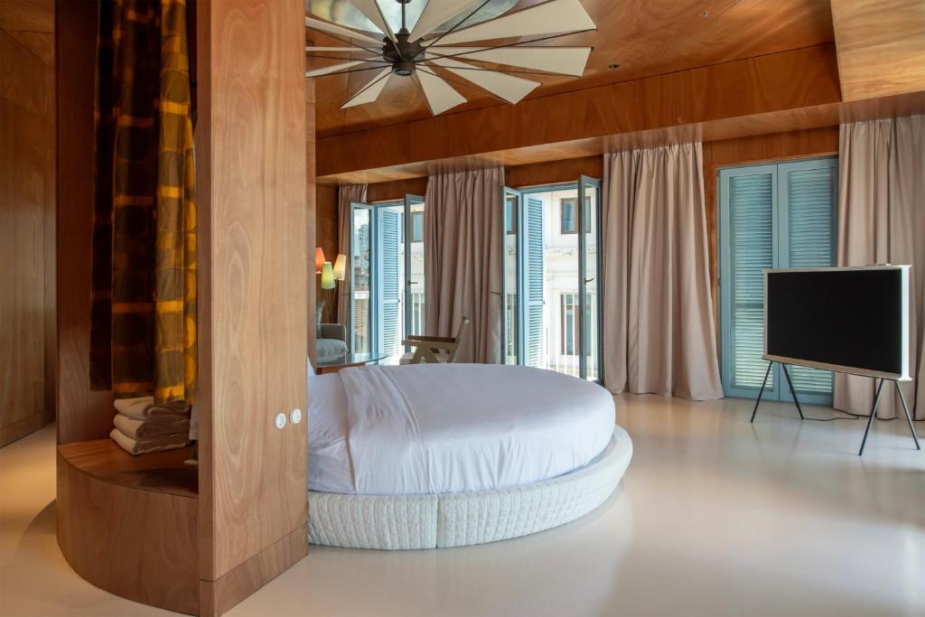 a bedroom with a bed and a flat screen tv at Rooms Hotel Batumi in Batumi