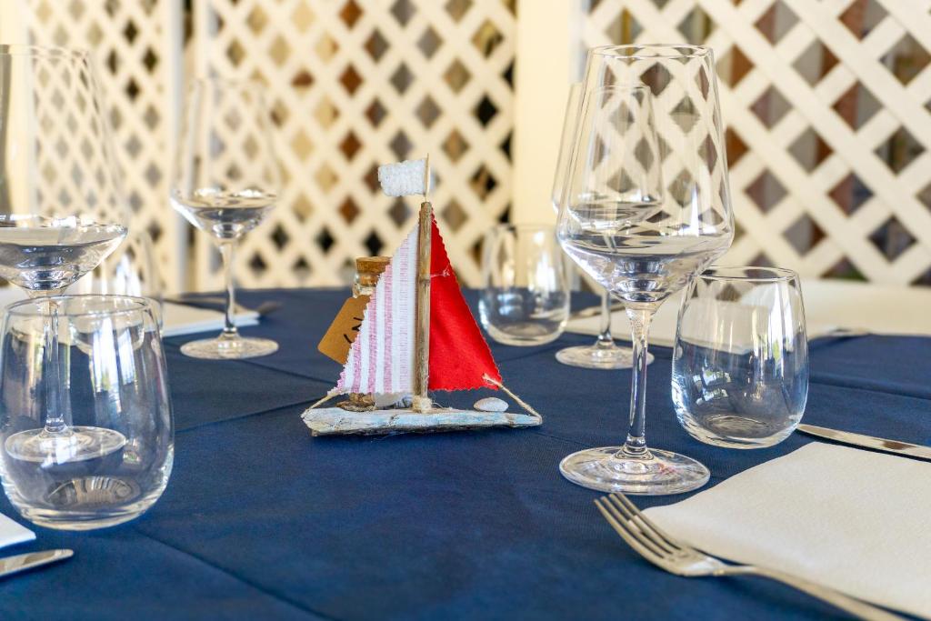 a table with wine glasses and a small boat on it at Hotel Il Perseo in Chiessi