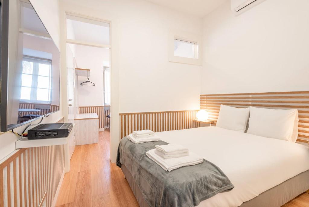 una camera da letto con un letto e una scrivania con una televisione di GuestReady - Urban Garden Apartments a Lisbona