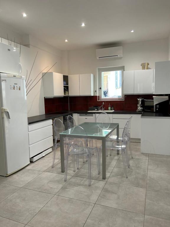 une cuisine avec une table, des chaises et un réfrigérateur dans l'établissement Appart hyper centre Nice, à Nice