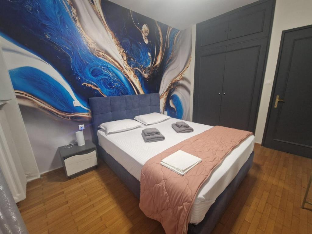 sypialnia z łóżkiem i obrazem na ścianie w obiekcie master1 seaside lux apartment w Salonikach