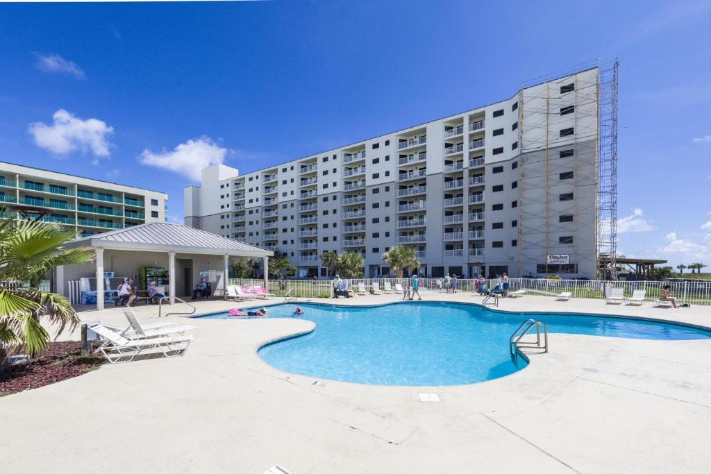 a large apartment building with a large swimming pool at Plantation Dunes Condos in Gulf Shores