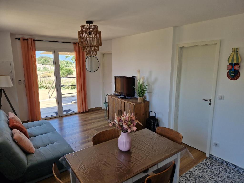 un salon avec une table et un canapé dans l'établissement T2 Neuf climatisé dans villa à Corbara, à Corbara