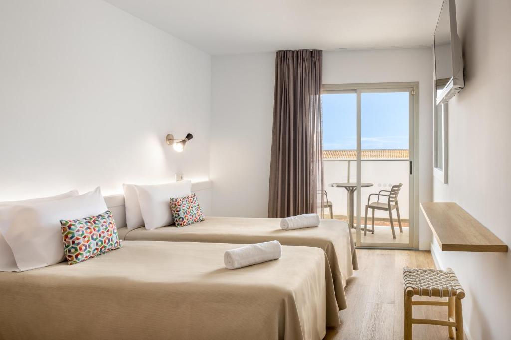 a hotel room with two beds and a balcony at htop Amatista #htopBliss in Lloret de Mar