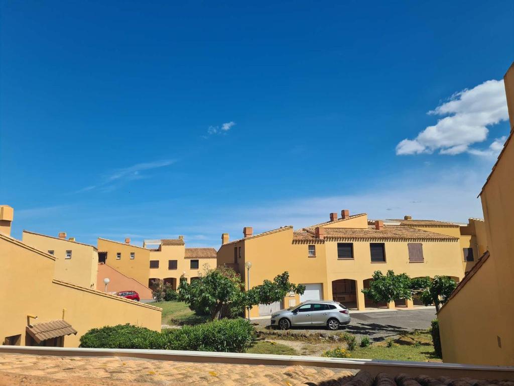 une voiture garée dans un parking en face des bâtiments dans l'établissement Appartement T2 avec Parking et Accès Direct à la Plage - FR-1-249-129, au Cap d'Agde