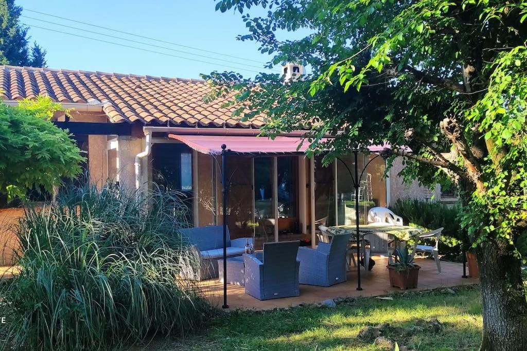 une maison avec un auvent rose et un patio dans l'établissement Villa Les Brouadettes, à Montfort-sur-Argens