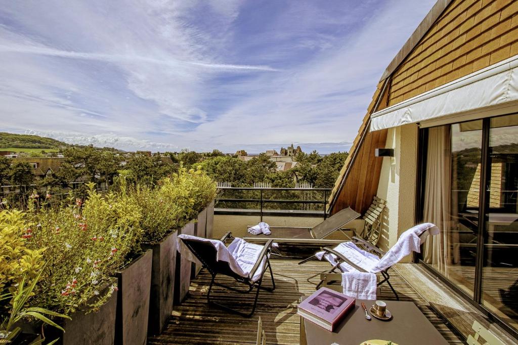 d'un balcon avec des chaises et une table sur une maison. dans l'établissement Le Roof Top-Apt T4-Proche Mer et Centre Ville, à Deauville