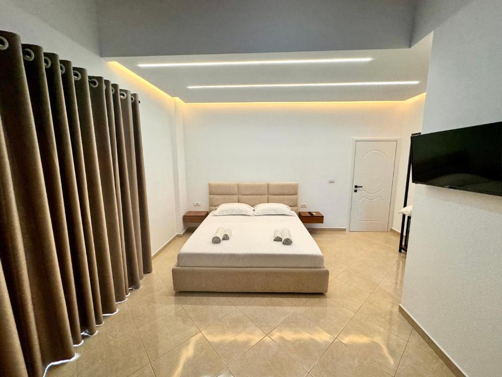 a bedroom with a bed in a room with curtains at Dine Hotel in Ksamil