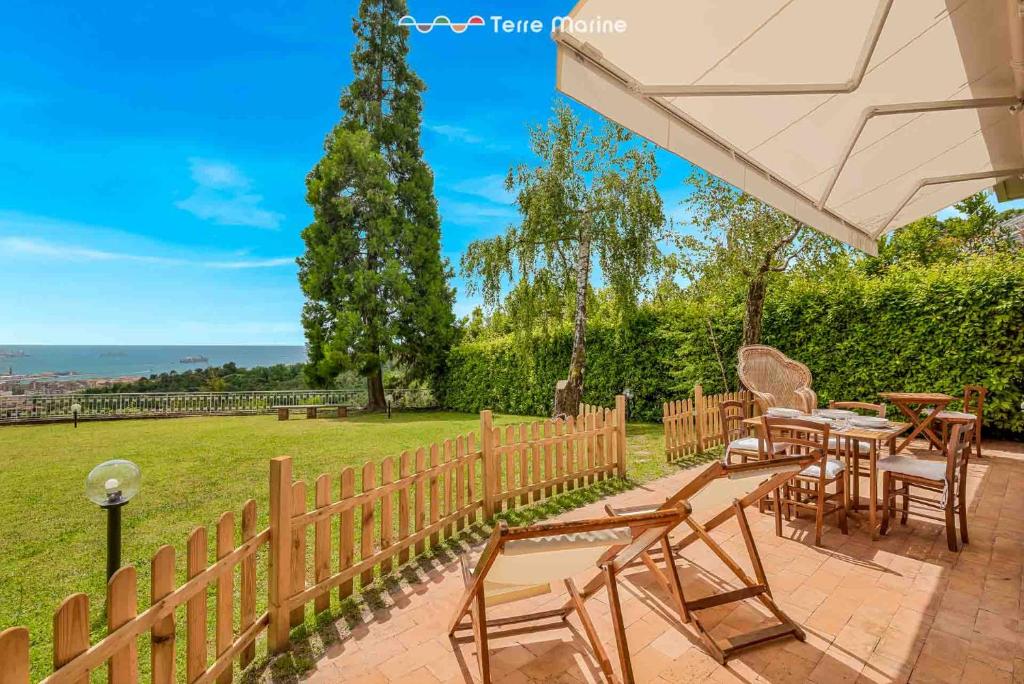a patio with tables and chairs and a fence at Ai Colli 136, Terre Marine in La Spezia