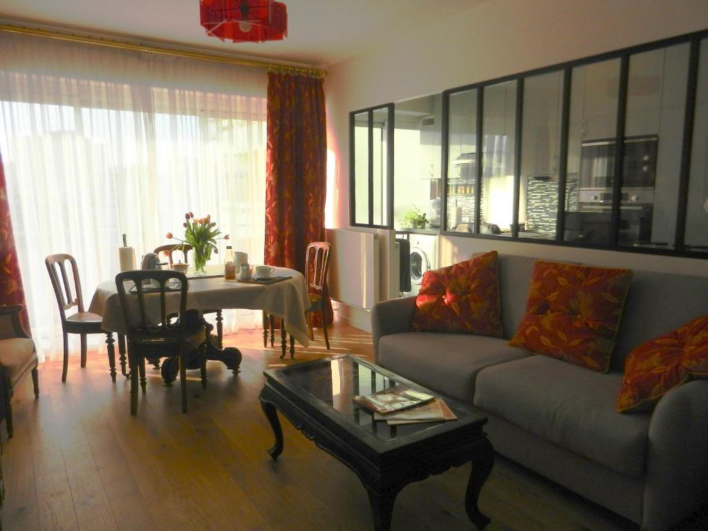 un salon avec un canapé et une table dans l'établissement Deux pièces de standing, climatisé, à Paris