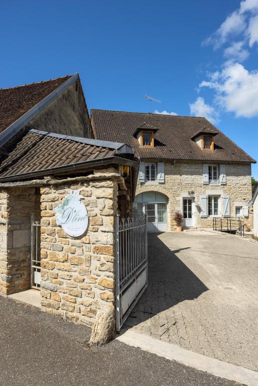 un bâtiment en pierre avec une porte en face d'une maison dans l'établissement gite D'line, à Voiteur