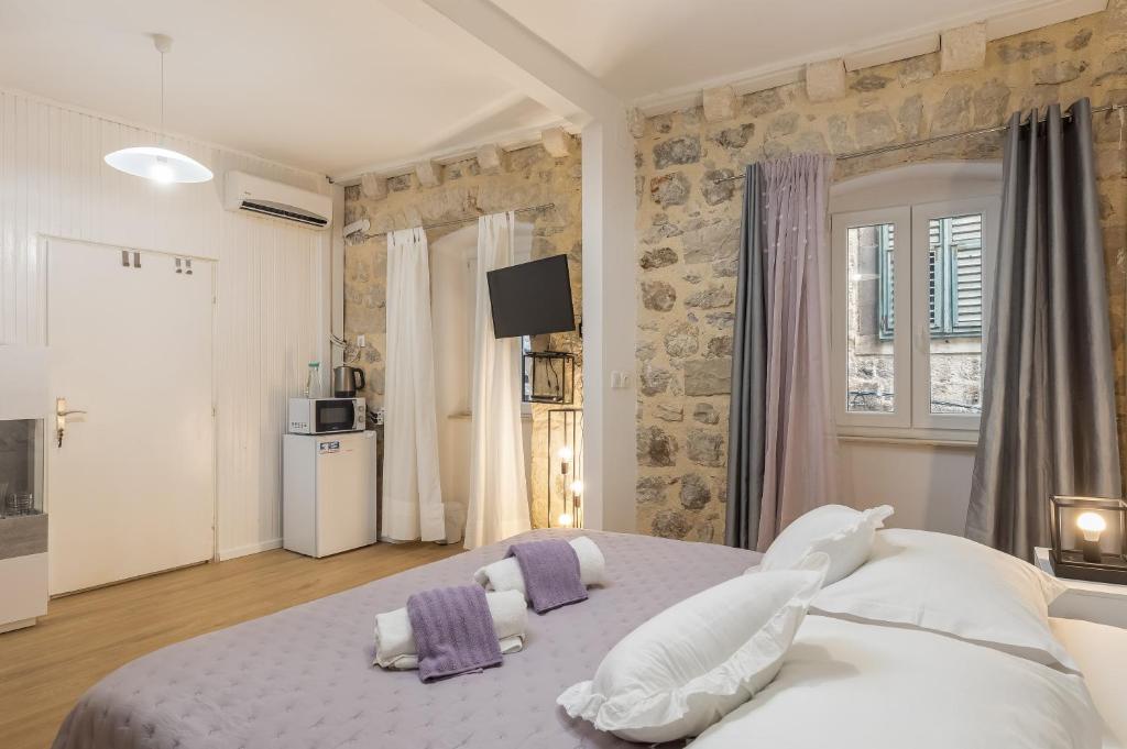 Un dormitorio con una cama grande con almohadas. en Guest House Tomasi Suite, en Dubrovnik