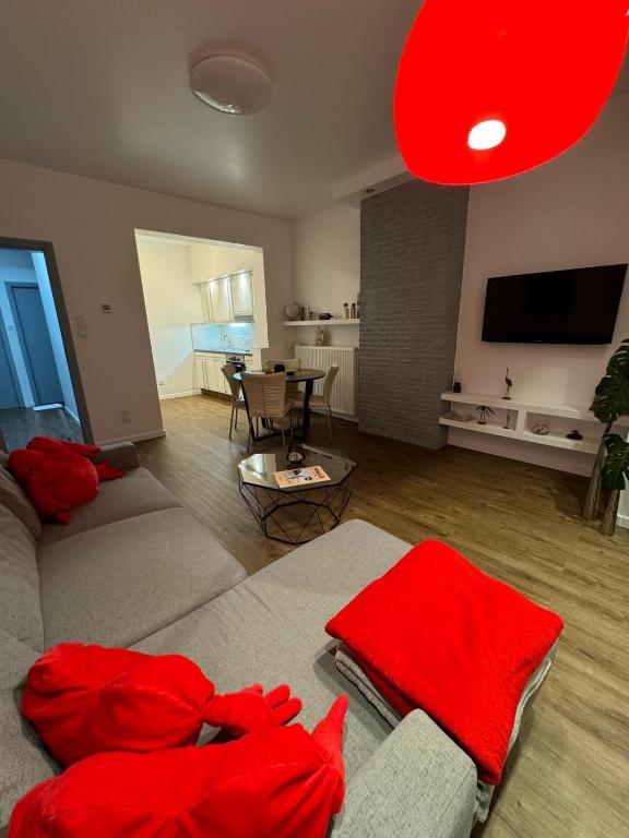ein Wohnzimmer mit roten Kissen auf der Couch in der Unterkunft Rachelle in Blankenberge