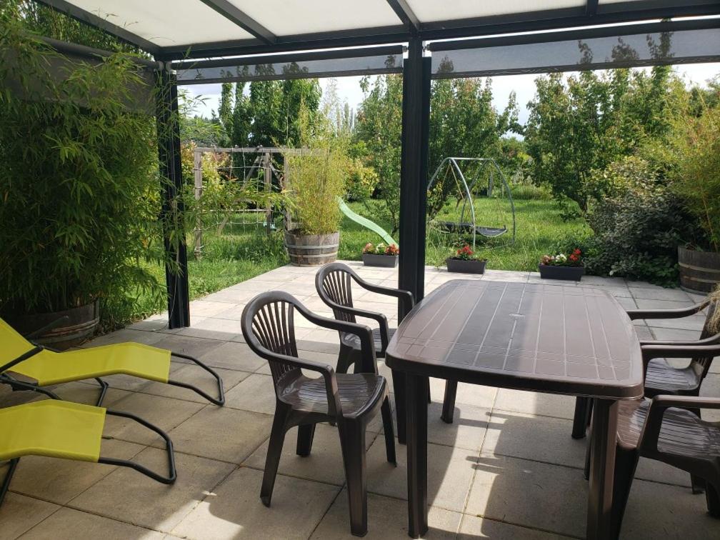 un patio avec une table et des chaises sur un patio dans l'établissement Chambre d'hôtes Jonquières, à Jonquières