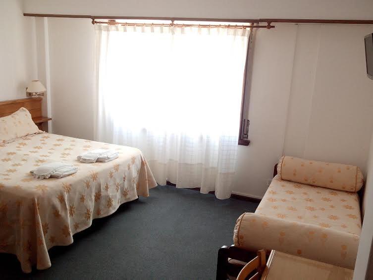 un dormitorio con dos camas y una mesa en el Hotel de Música Montecarlo de Villa Gesell